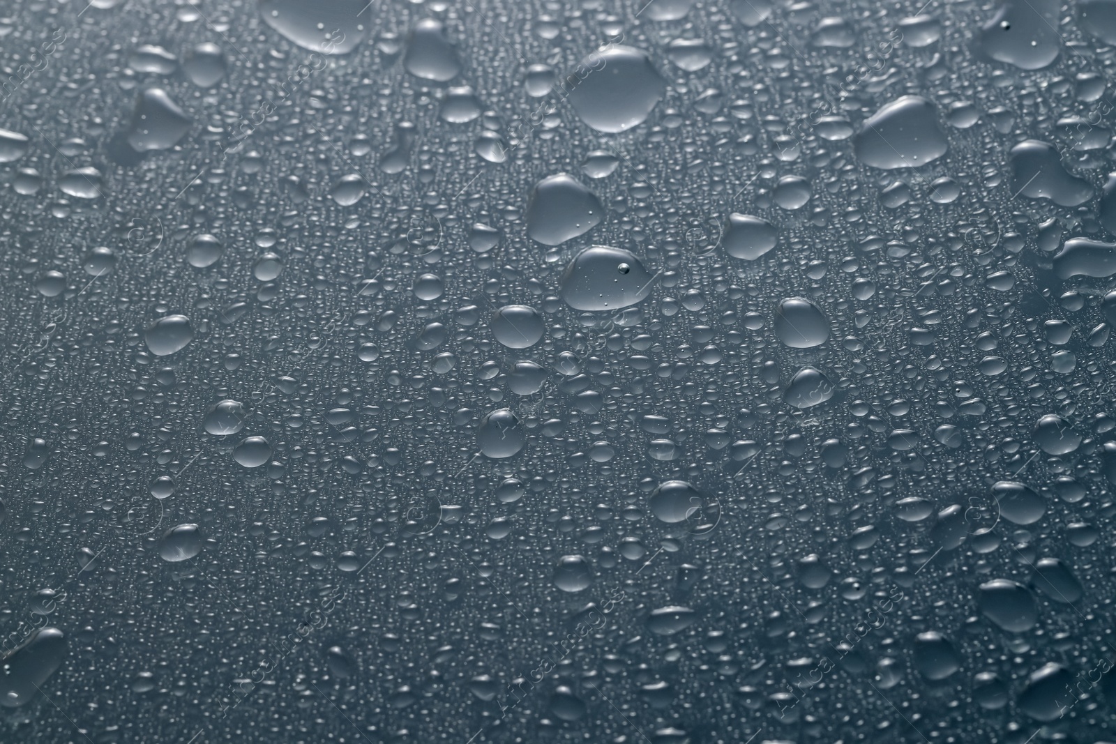 Photo of Water drops on grey glass surface, top view