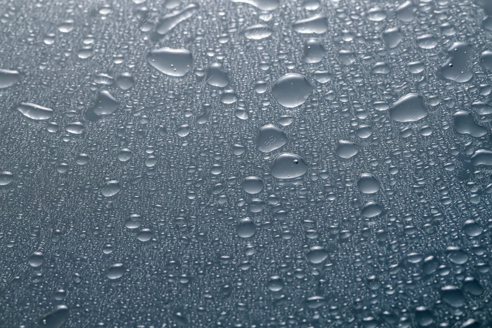 Photo of Water drops on grey glass surface, top view