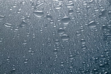 Photo of Water drops on grey glass surface, top view