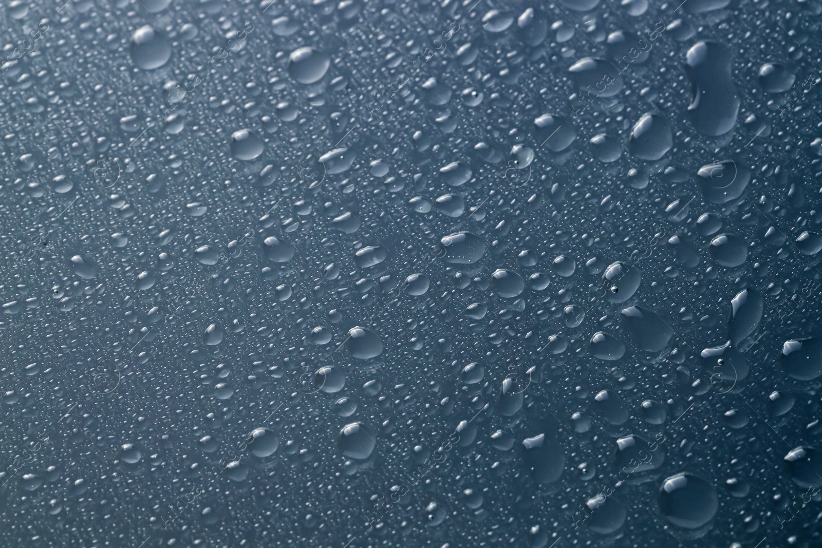 Photo of Water drops on grey glass surface, top view