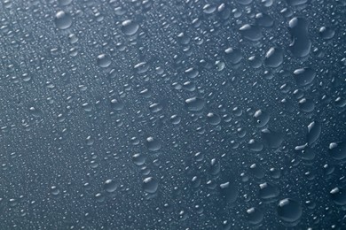 Water drops on grey glass surface, top view