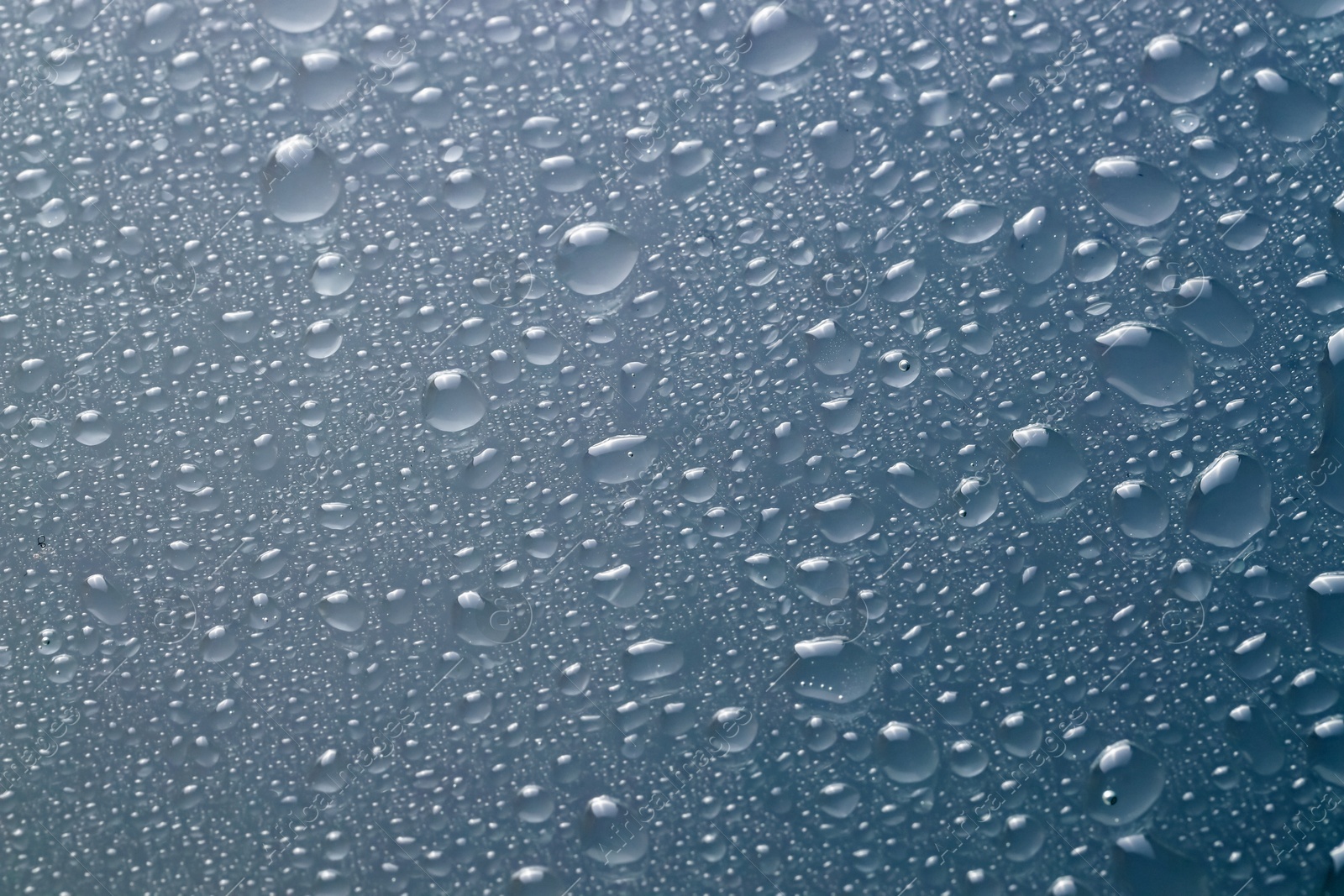 Photo of Water drops on light glass surface, top view