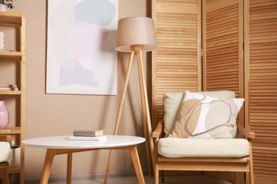 Photo of Stylish coffee table with books near armchair at home