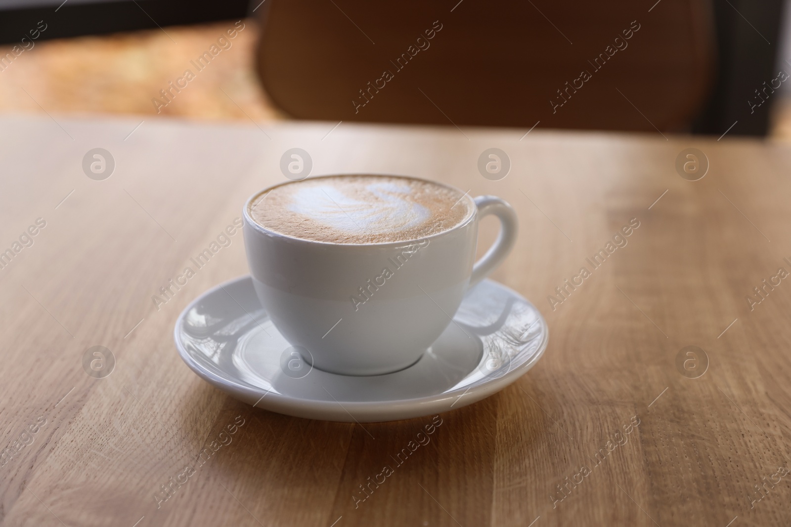 Photo of Cup of aromatic coffee on wooden table in cafe