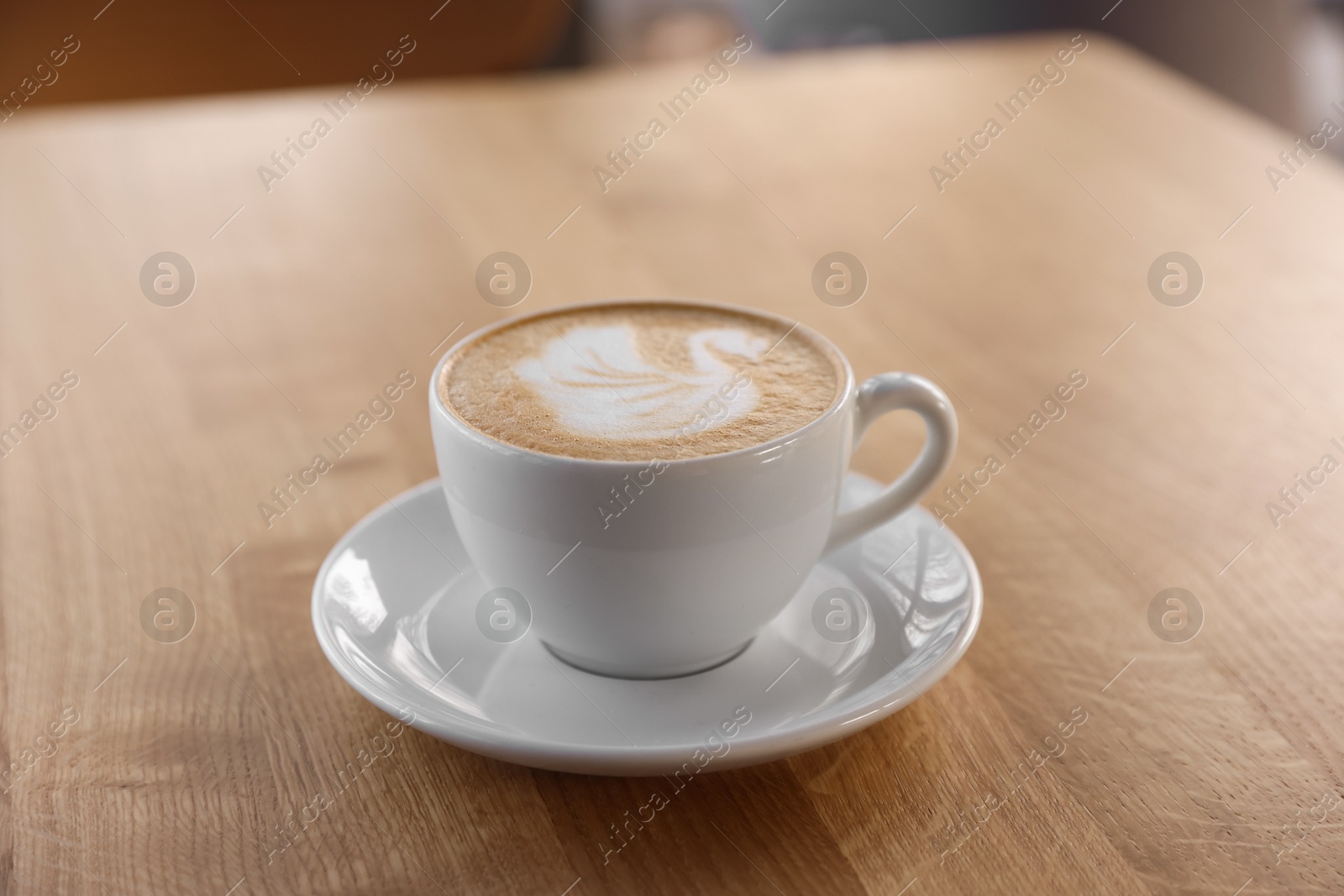 Photo of Cup of aromatic coffee on wooden table in cafe, closeup