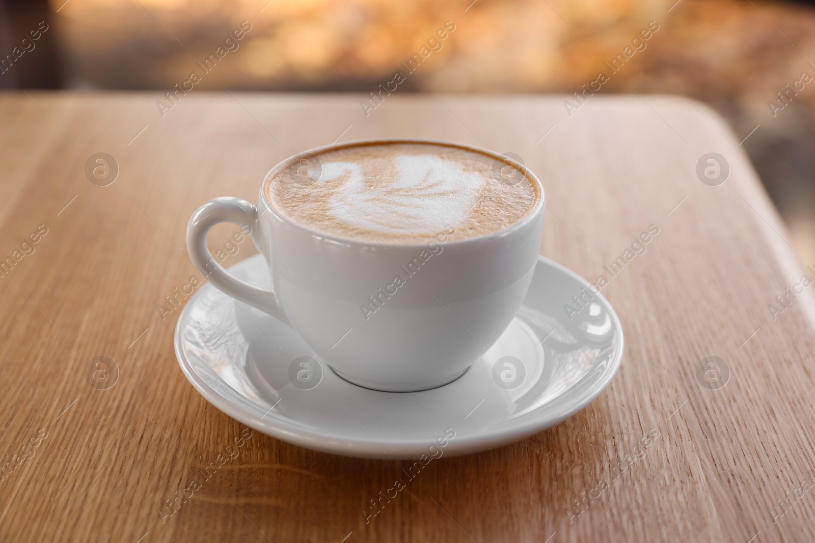 Photo of Cup of aromatic coffee on wooden table in cafe, closeup