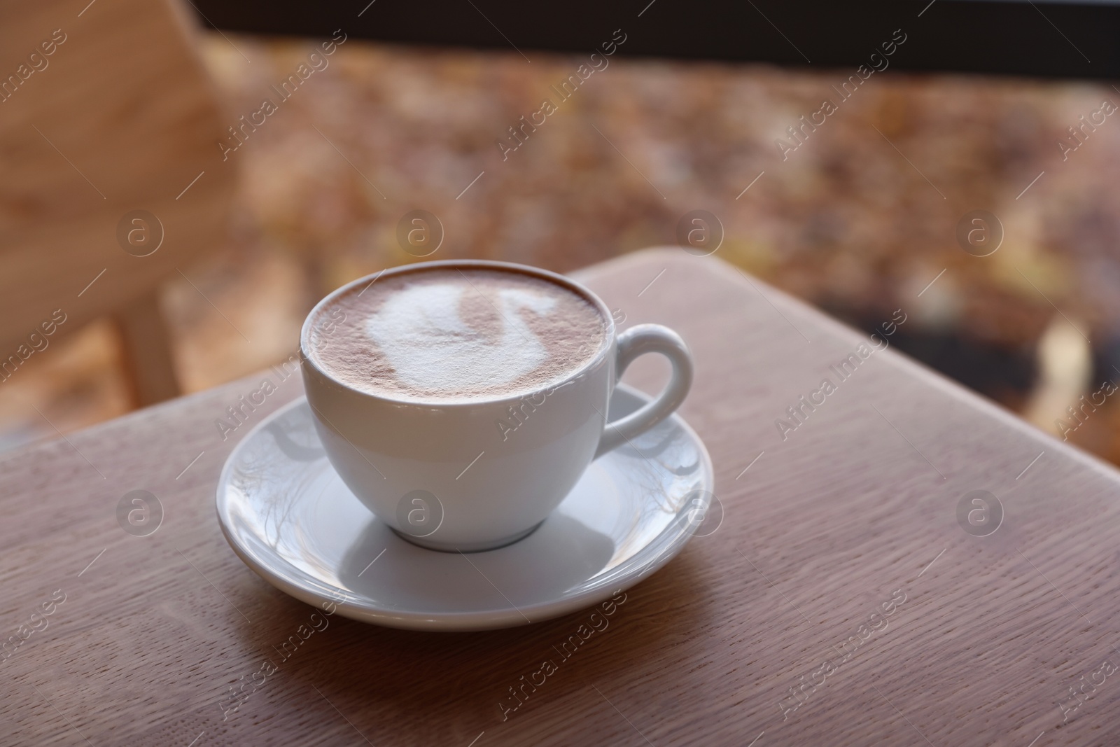 Photo of Cup of aromatic coffee on wooden table in cafe, closeup