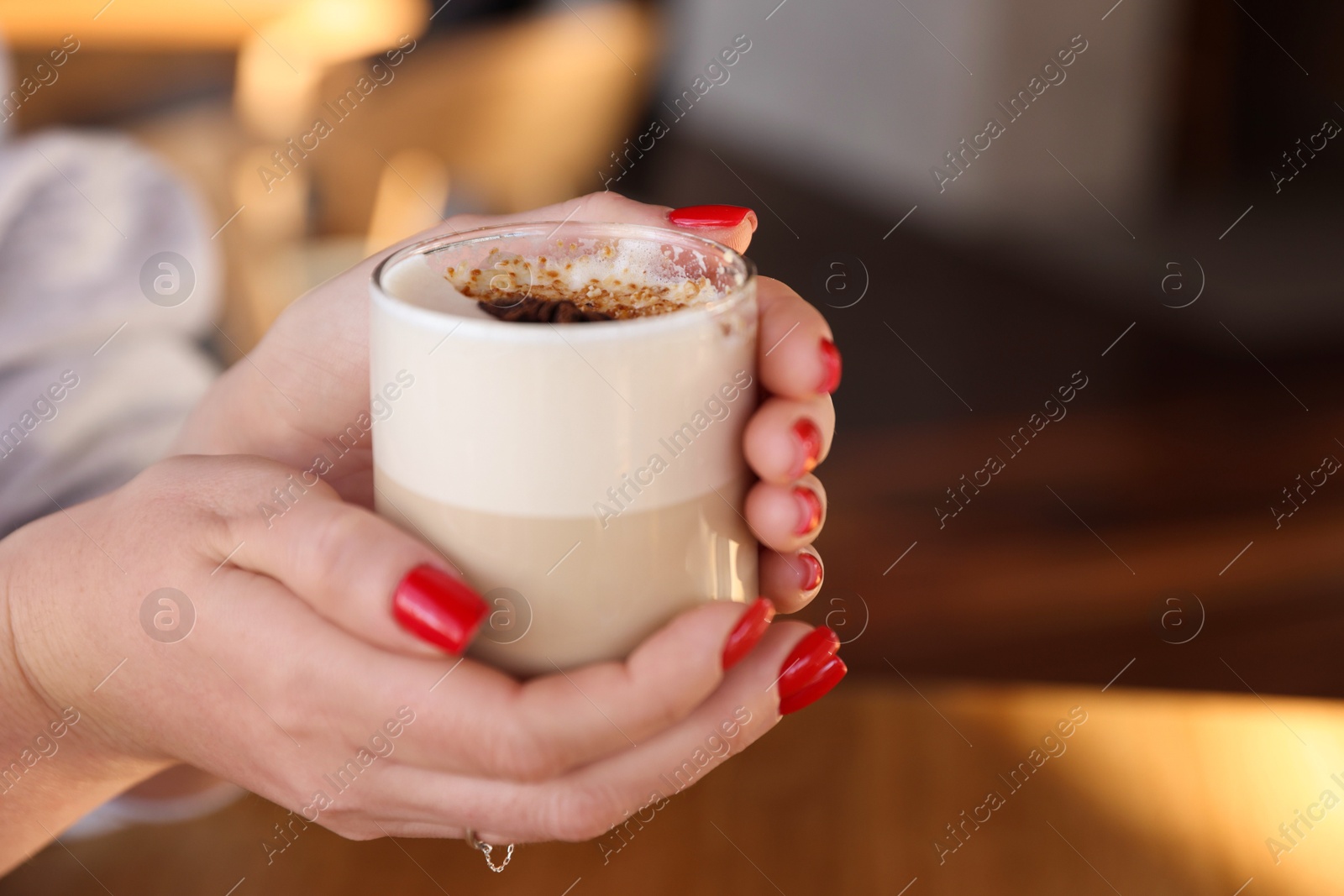 Photo of Woman with glass of aromatic coffee in cafe, closeup. Space for text