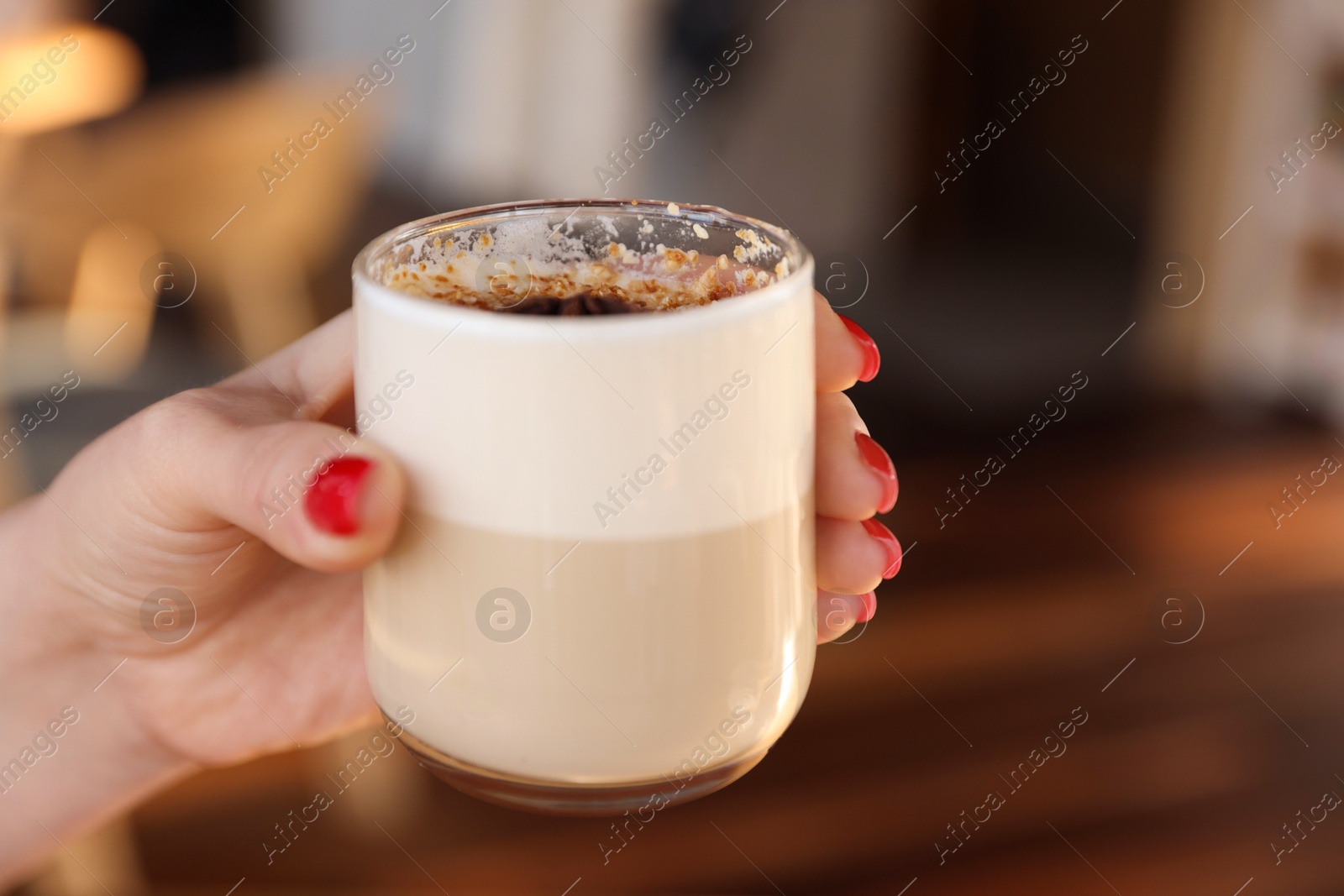 Photo of Woman with glass of aromatic coffee in cafe, closeup. Space for text