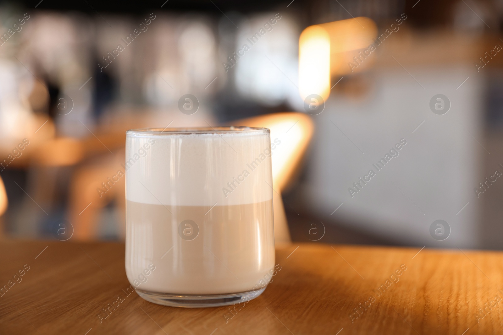 Photo of Glass of aromatic coffee on wooden table in cafe, closeup. Space for text