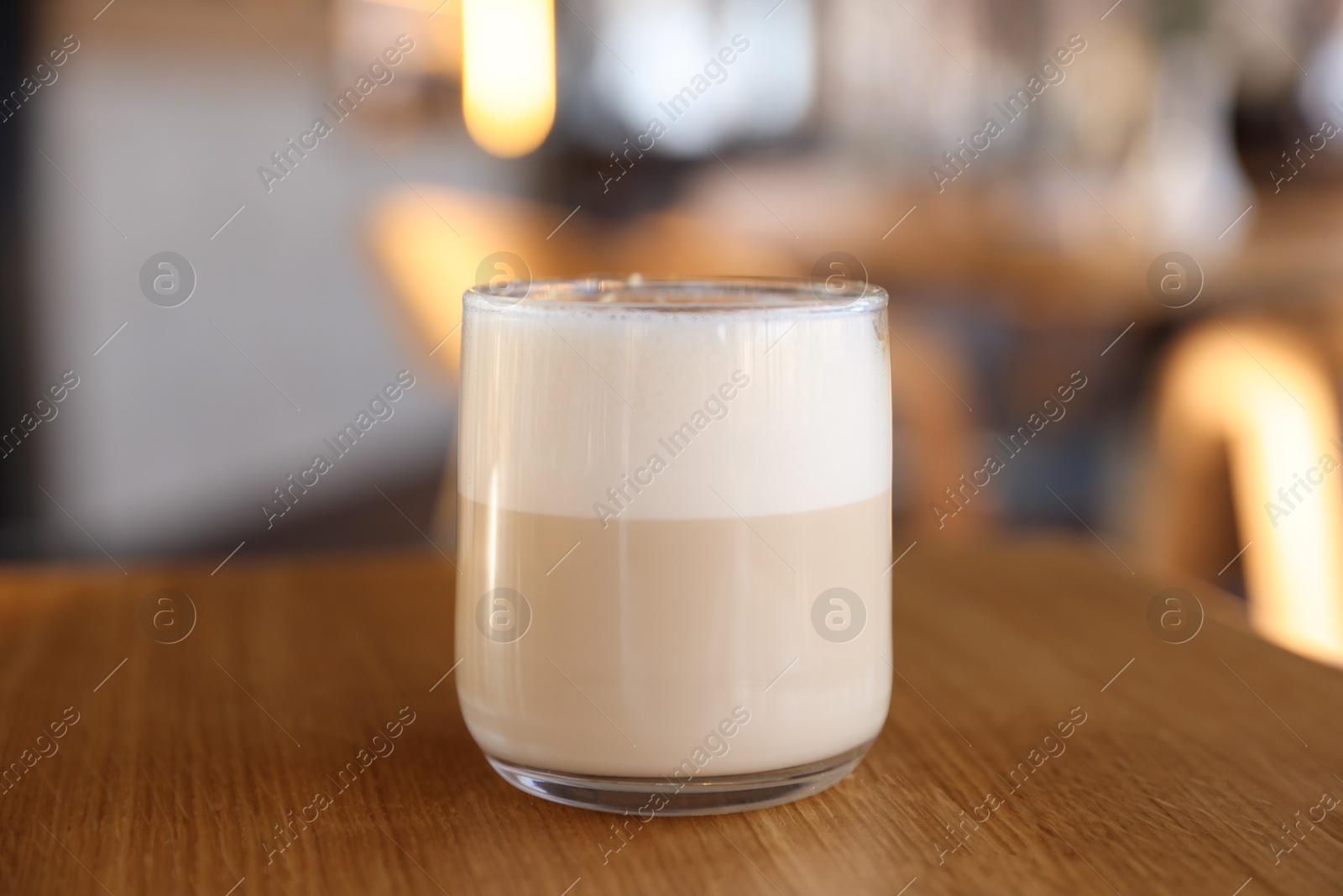 Photo of Glass of aromatic coffee on wooden table in cafe, closeup