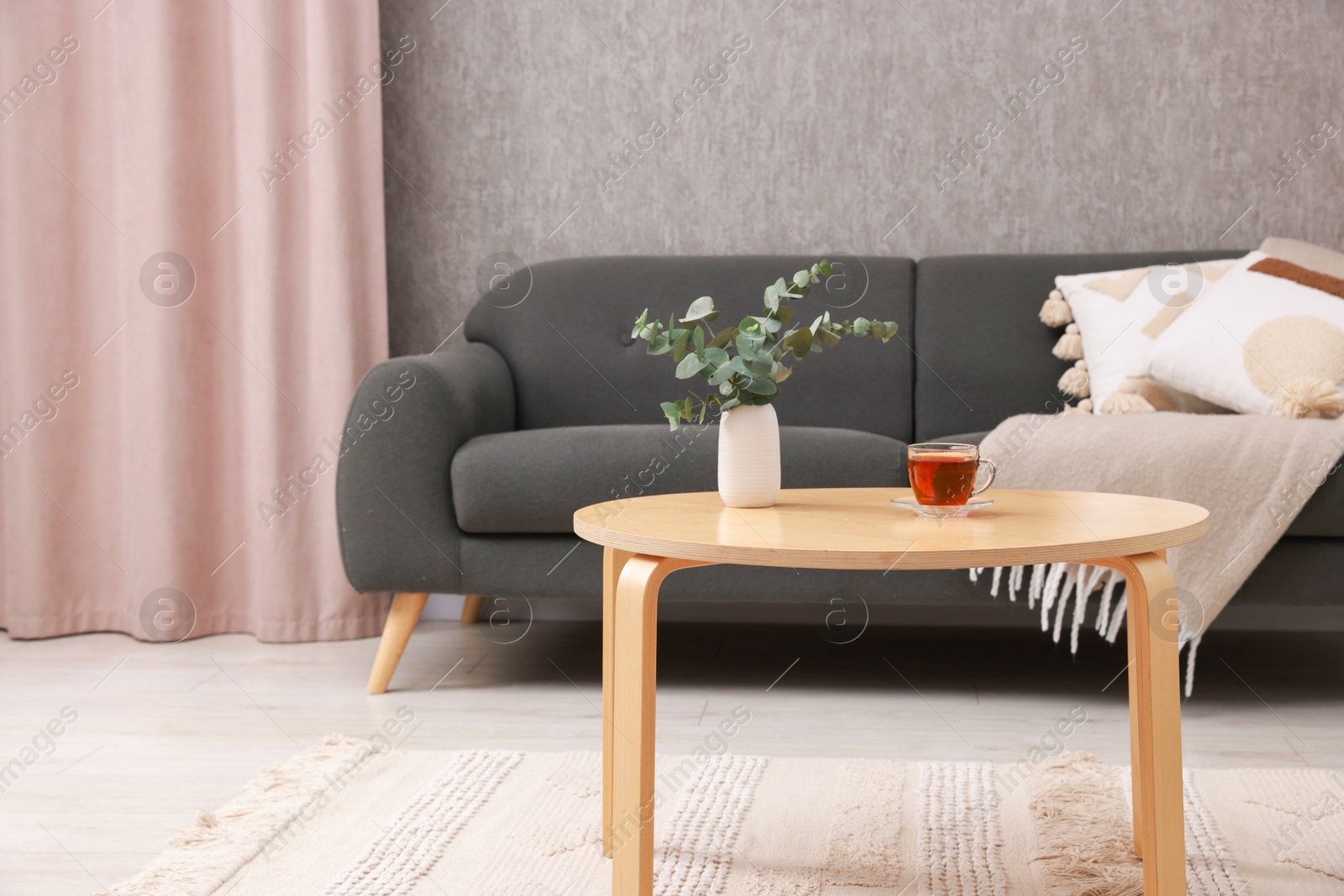 Photo of Coffee table with tea and eucalyptus at home