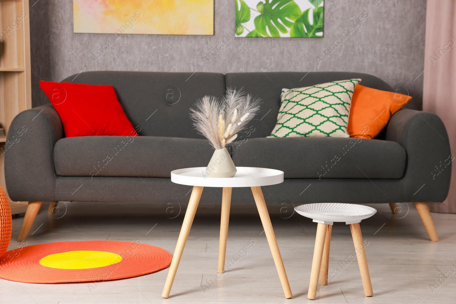 Photo of Stylish nesting tables near sofa at home