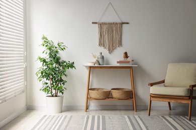 Photo of Stylish room interior with console table near white wall