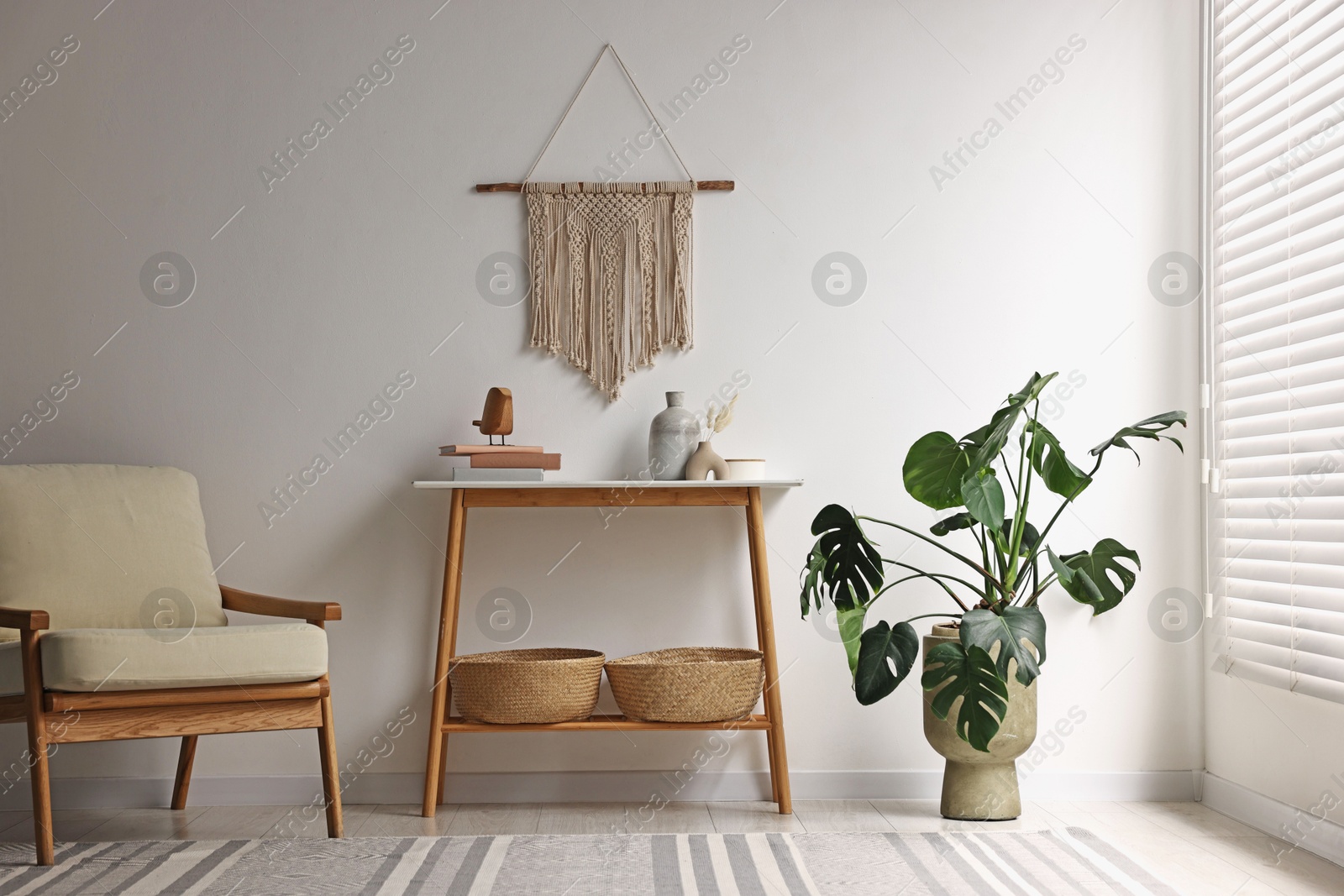 Photo of Stylish room interior with console table near white wall