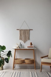 Photo of Stylish room interior with console table near white wall