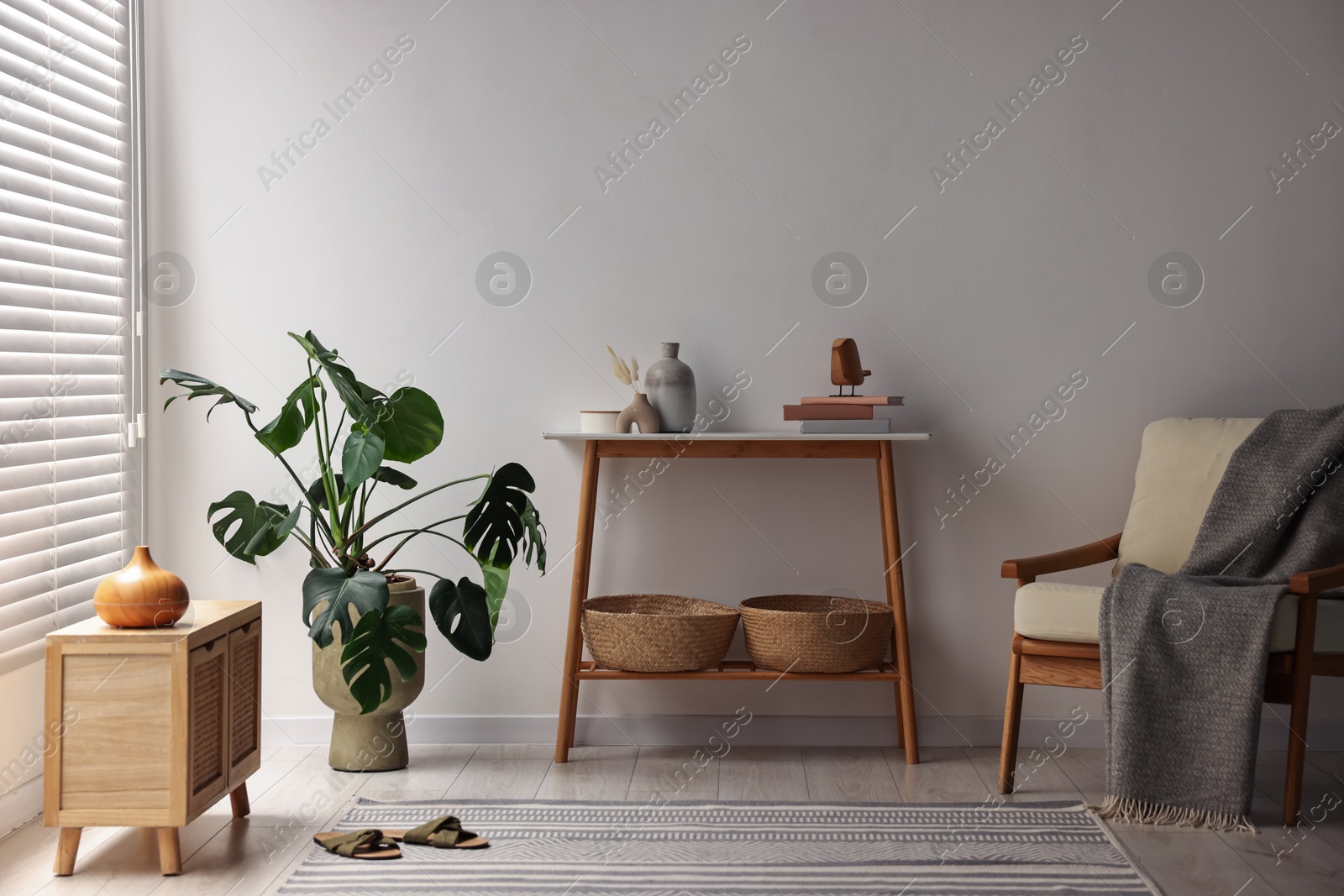 Photo of Stylish room interior with console table near white wall