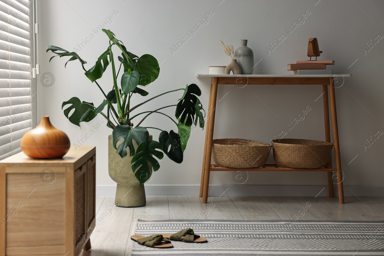 Photo of Stylish room interior with console table near white wall