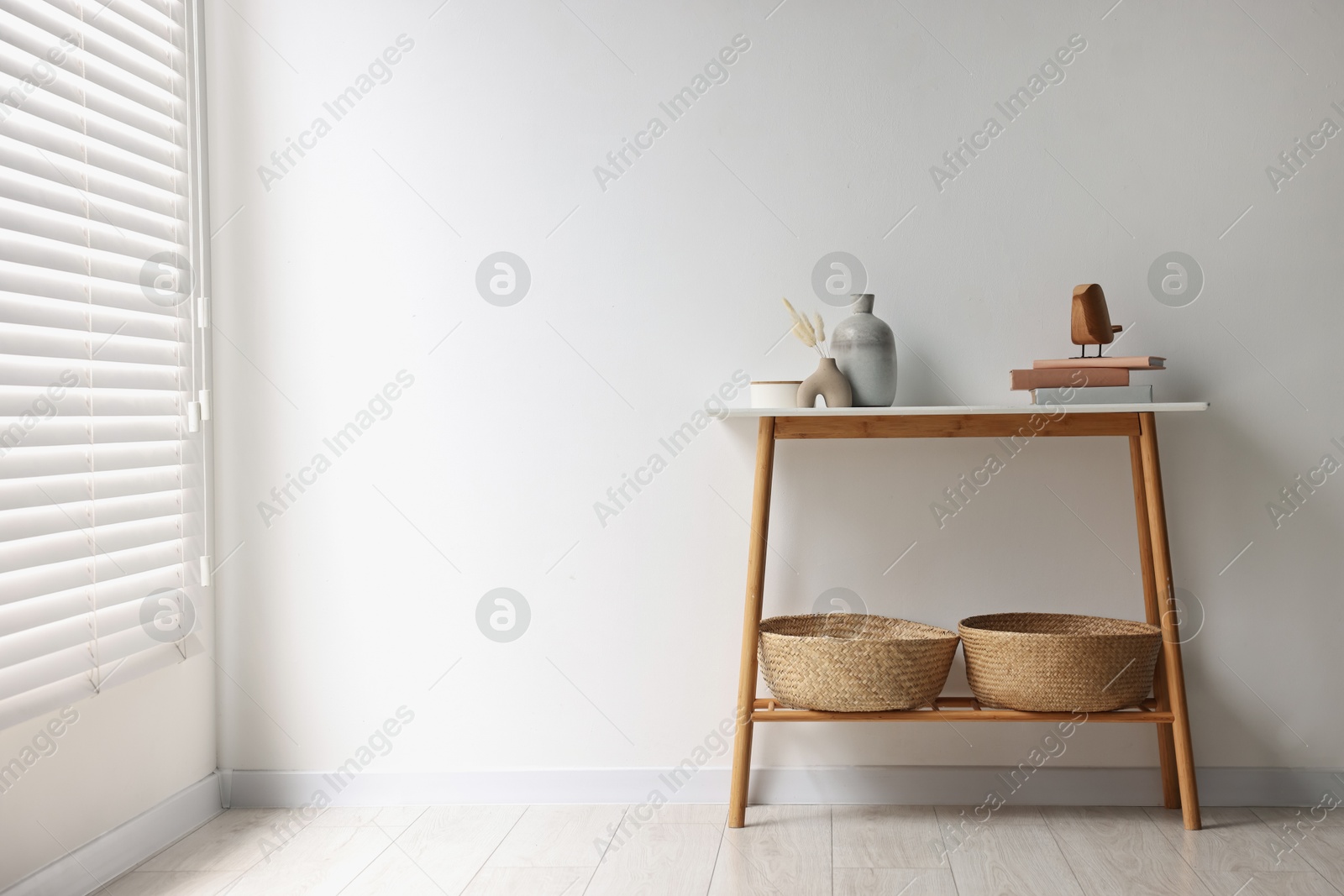 Photo of Stylish console table with decor near white wall indoors. Space for text