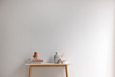 Photo of Stylish console table with decor near white wall indoors. Space for text