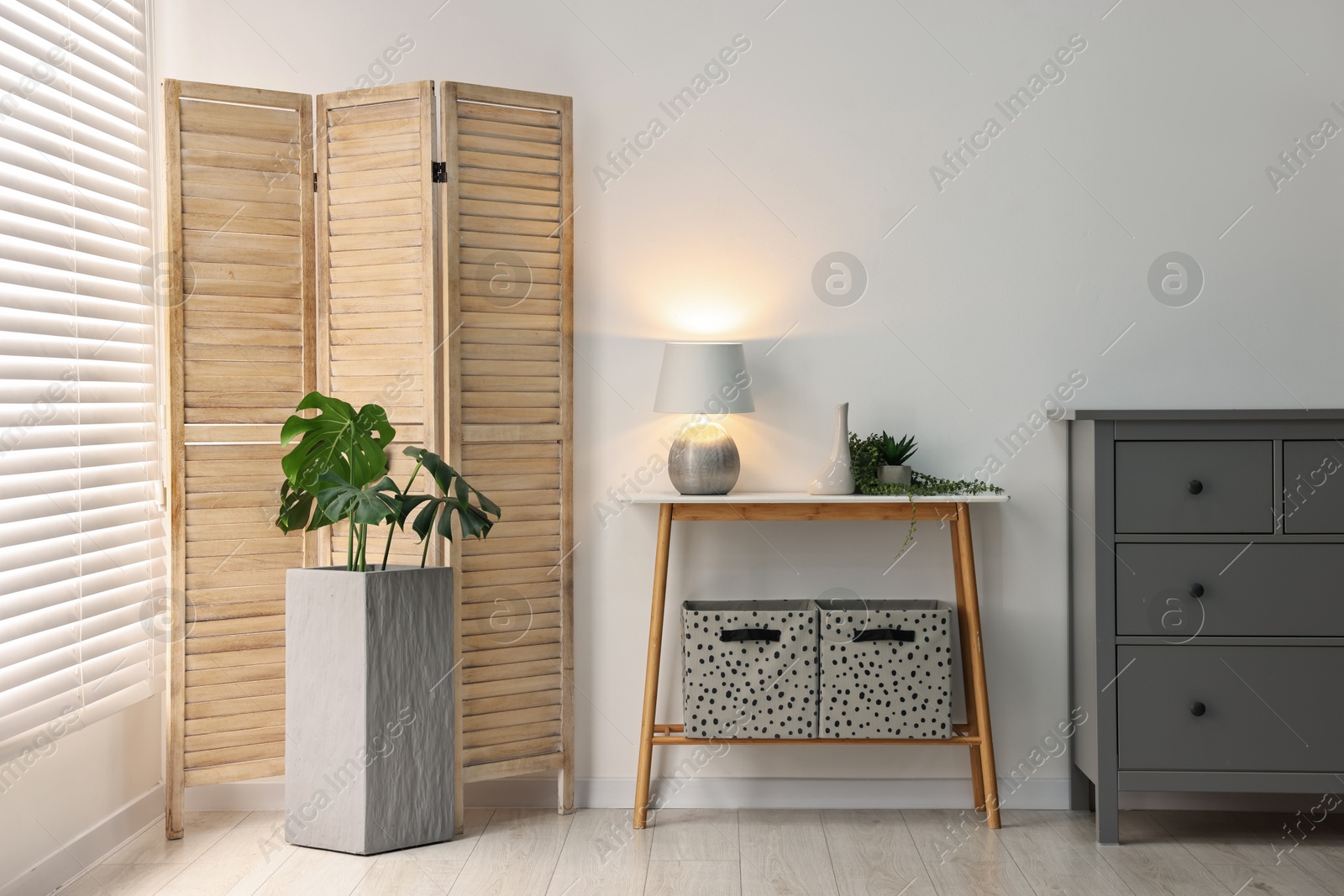 Photo of Stylish room interior with console table near white wall