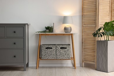 Photo of Stylish room interior with console table near white wall