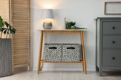 Photo of Stylish room interior with console table near white wall