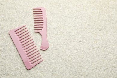 Photo of Different pink plastic combs on beige background, top view. Space for text