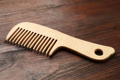 Photo of One hair comb on wooden background, closeup