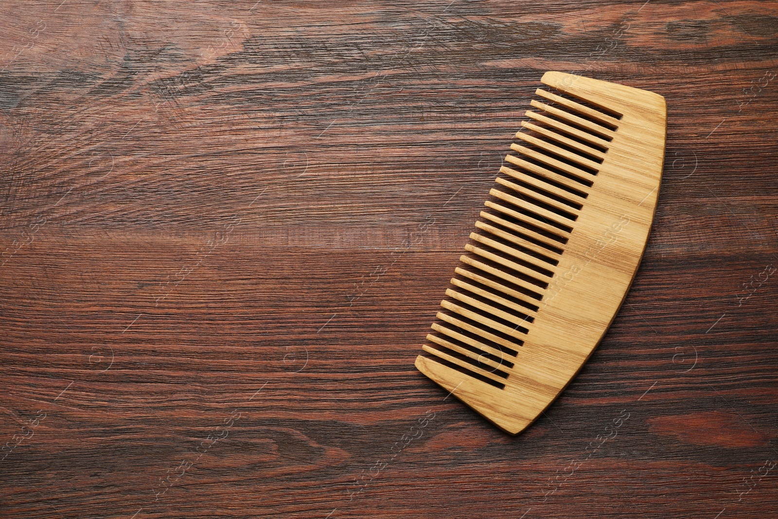 Photo of One hair comb on wooden background, top view. Space for text