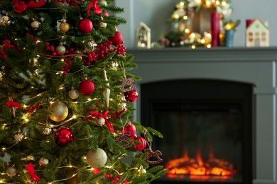 Photo of Beautiful decorated Christmas tree near fireplace at home, closeup. Space for text