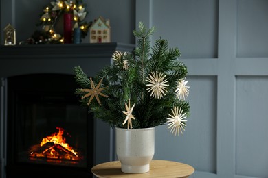 Photo of Decorated fir tree branches on table at home. Christmas decor