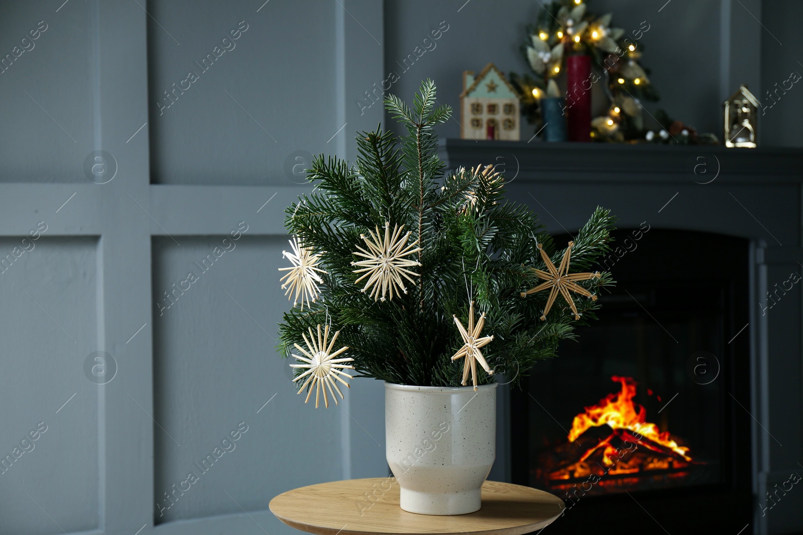 Photo of Decorated fir tree branches on table at home. Christmas decor