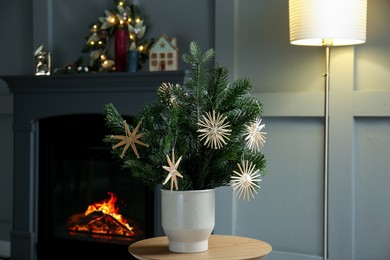 Photo of Decorated fir tree branches on table at home. Christmas decor