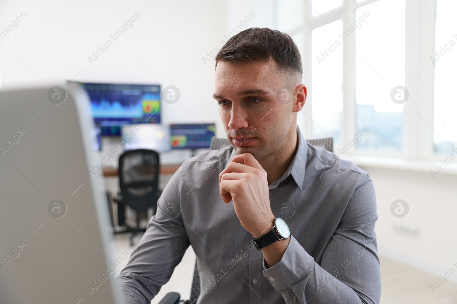 Photo of Financial trading specialist working on computer in office