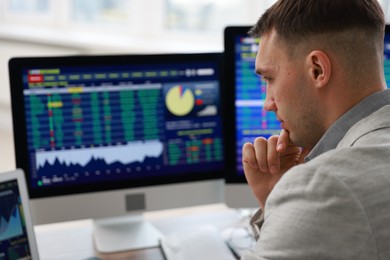 Photo of Financial trading specialist working on computer in office