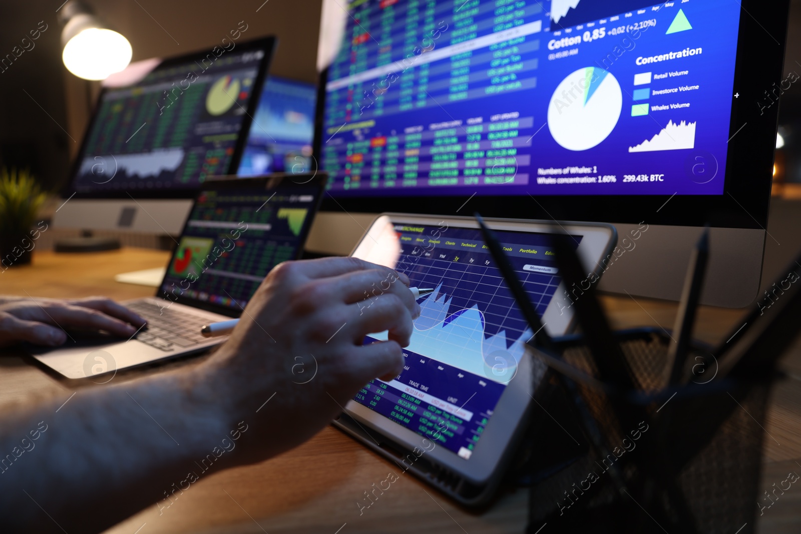 Photo of Financial trading specialist working on tablet in office at night, closeup