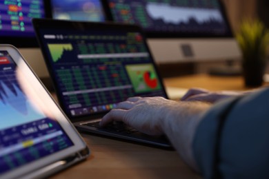 Photo of Financial trading specialist working on laptop in office at night, closeup