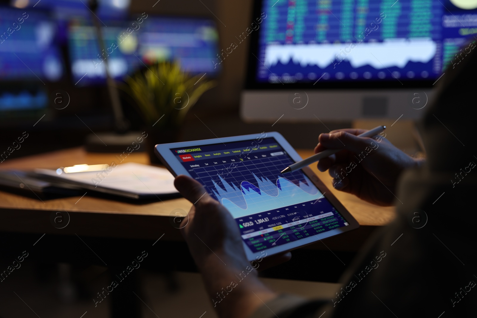 Photo of Financial trading specialist with tablet in office at night, closeup