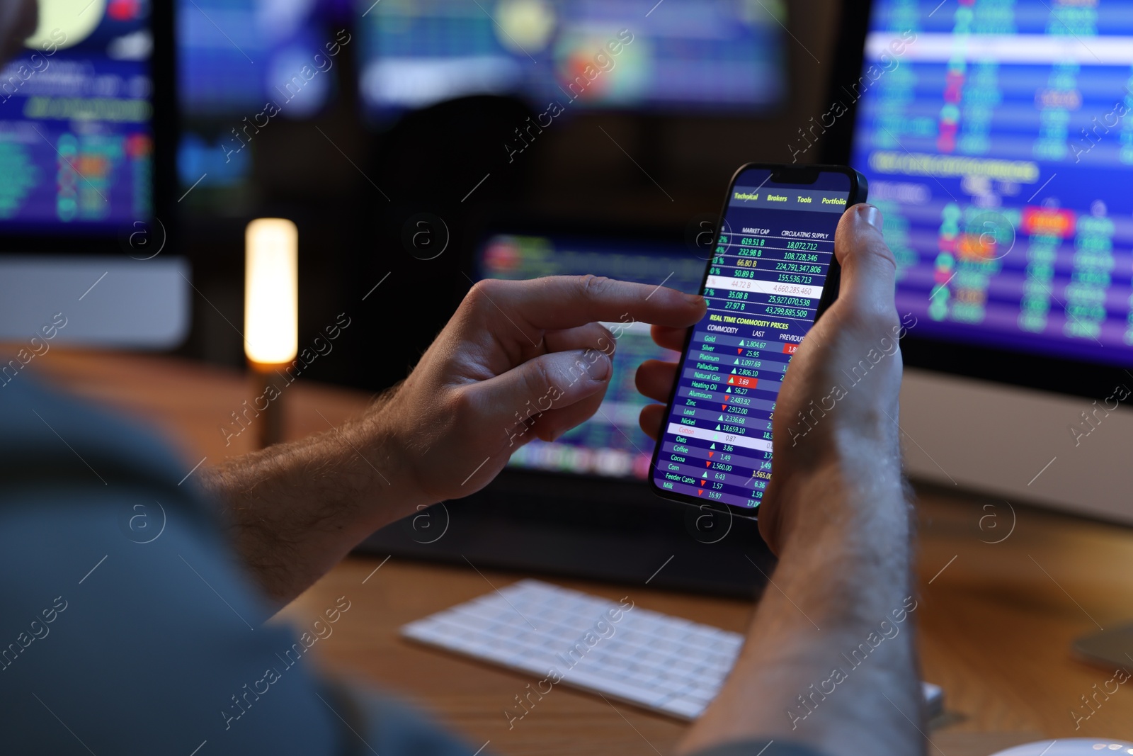 Photo of Financial trading specialist with smartphone in office at night, closeup