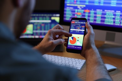 Photo of Financial trading specialist with smartphone in office at night, closeup