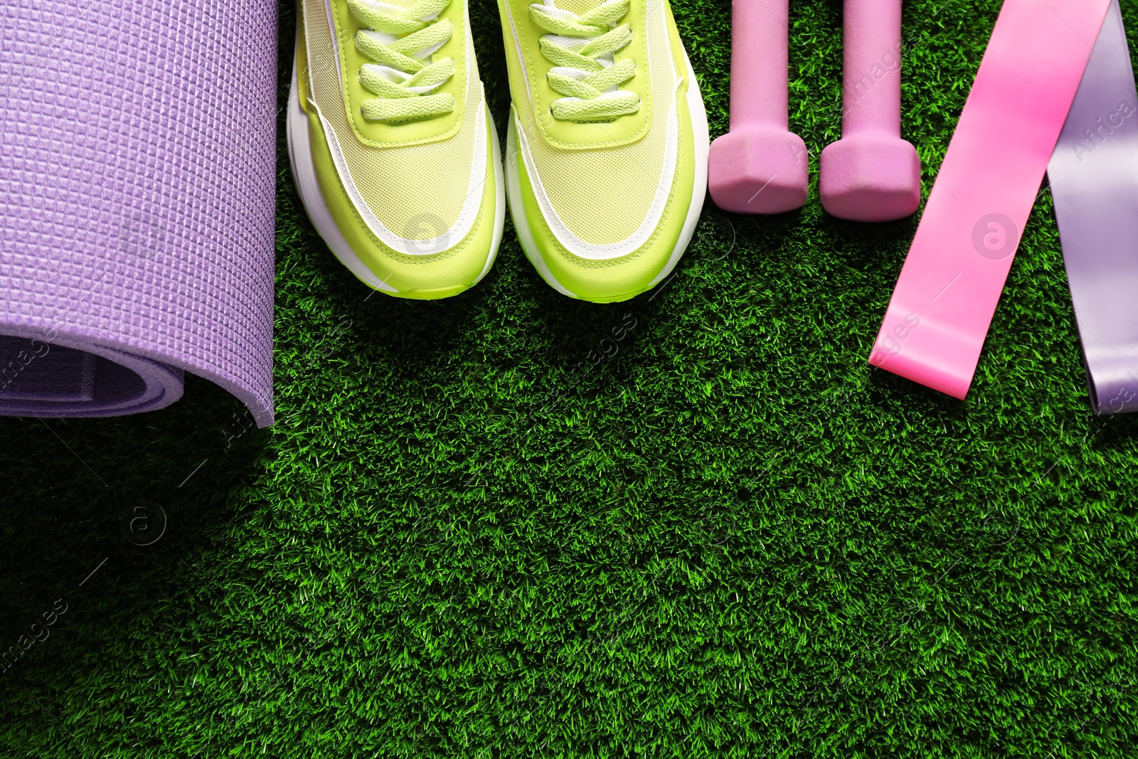 Photo of Different sports equipment on artificial grass, flat lay. Space for text