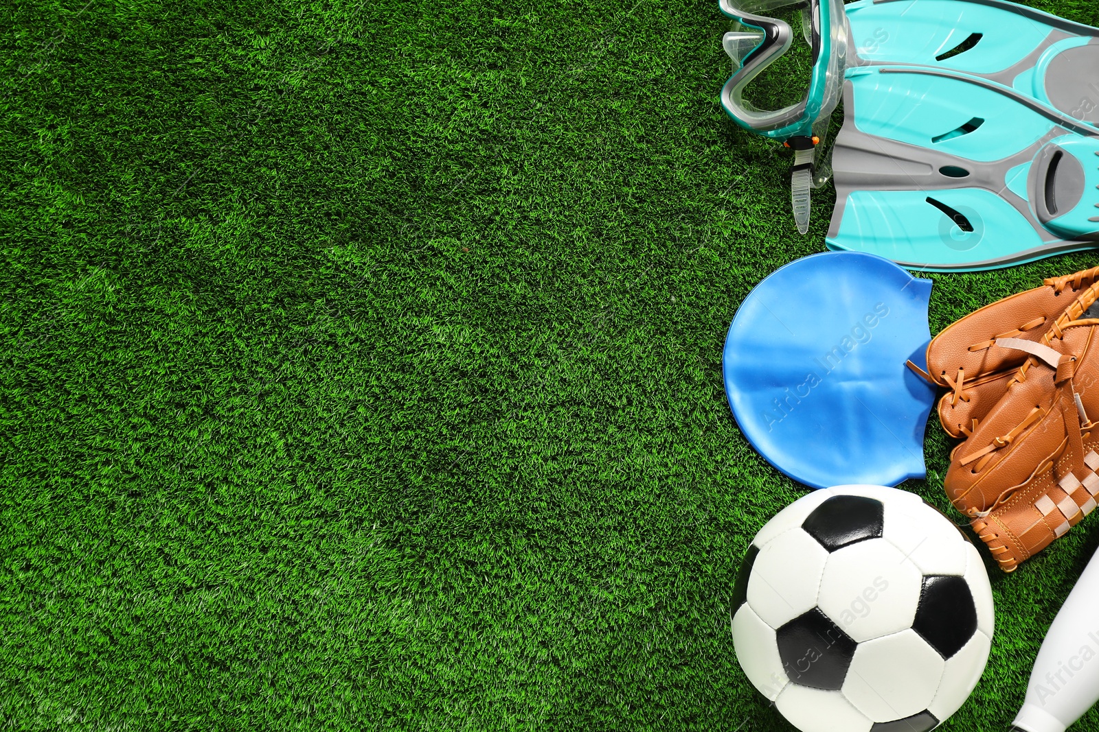 Photo of Different sports equipment on artificial grass, flat lay. Space for text