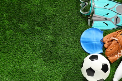 Photo of Different sports equipment on artificial grass, flat lay. Space for text