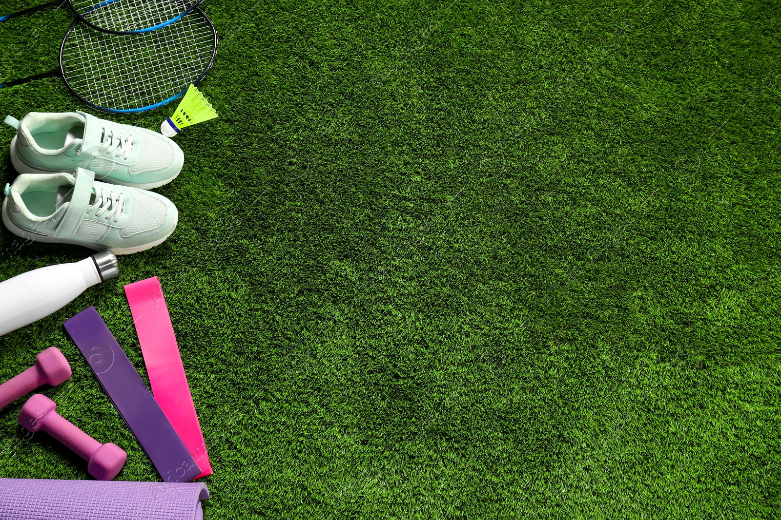 Photo of Different sports equipment on artificial grass, flat lay. Space for text