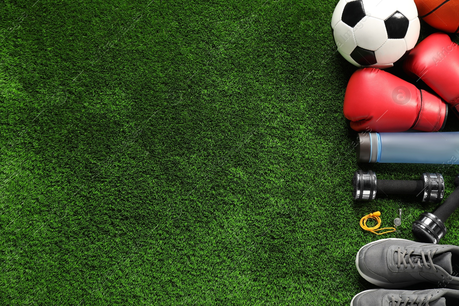 Photo of Different sports equipment on artificial grass, flat lay. Space for text