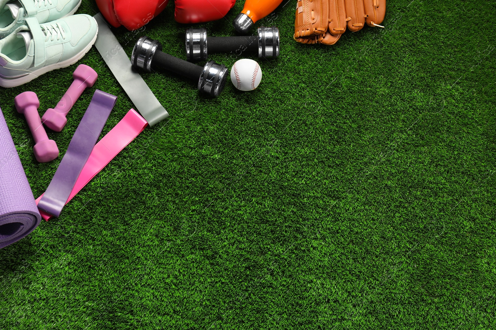 Photo of Different sports equipment on artificial grass, flat lay. Space for text