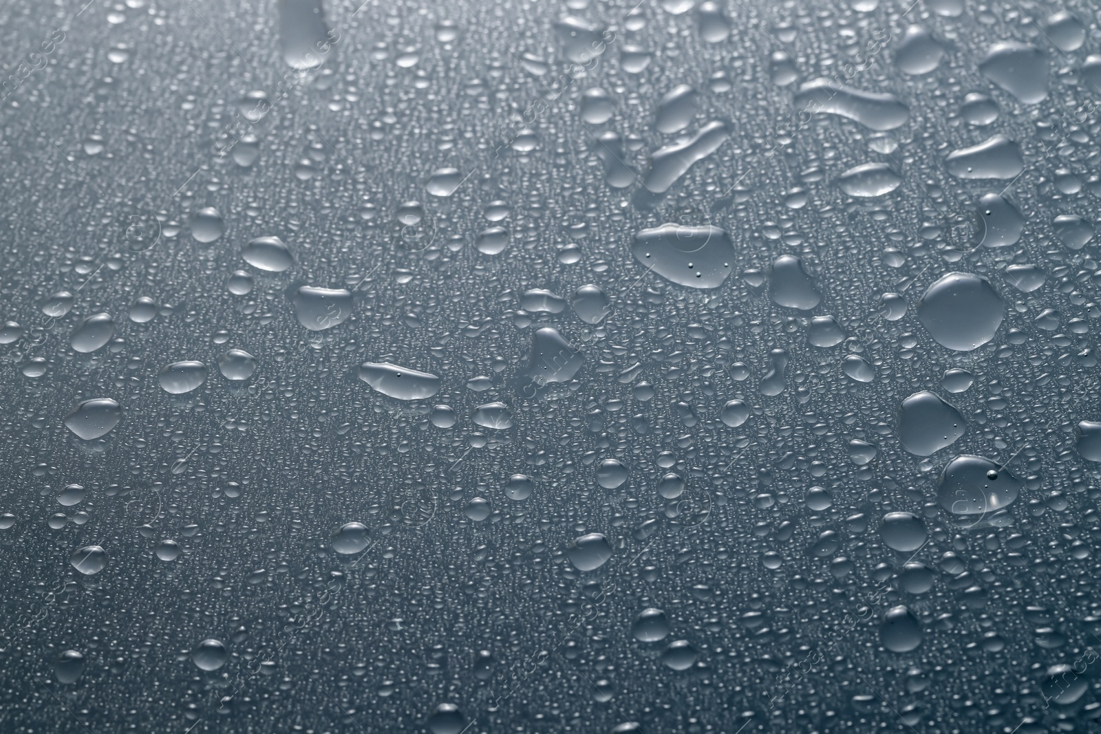 Photo of Water drops on grey glass surface, top view