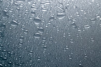 Photo of Water drops on light glass surface, top view