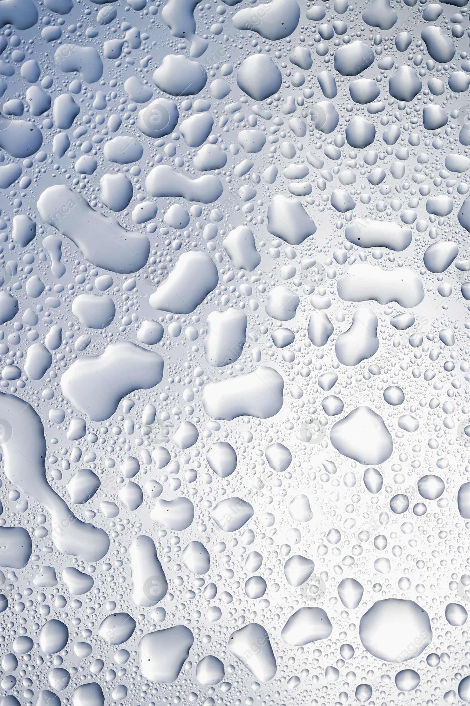 Photo of Water drops on light glass surface, top view